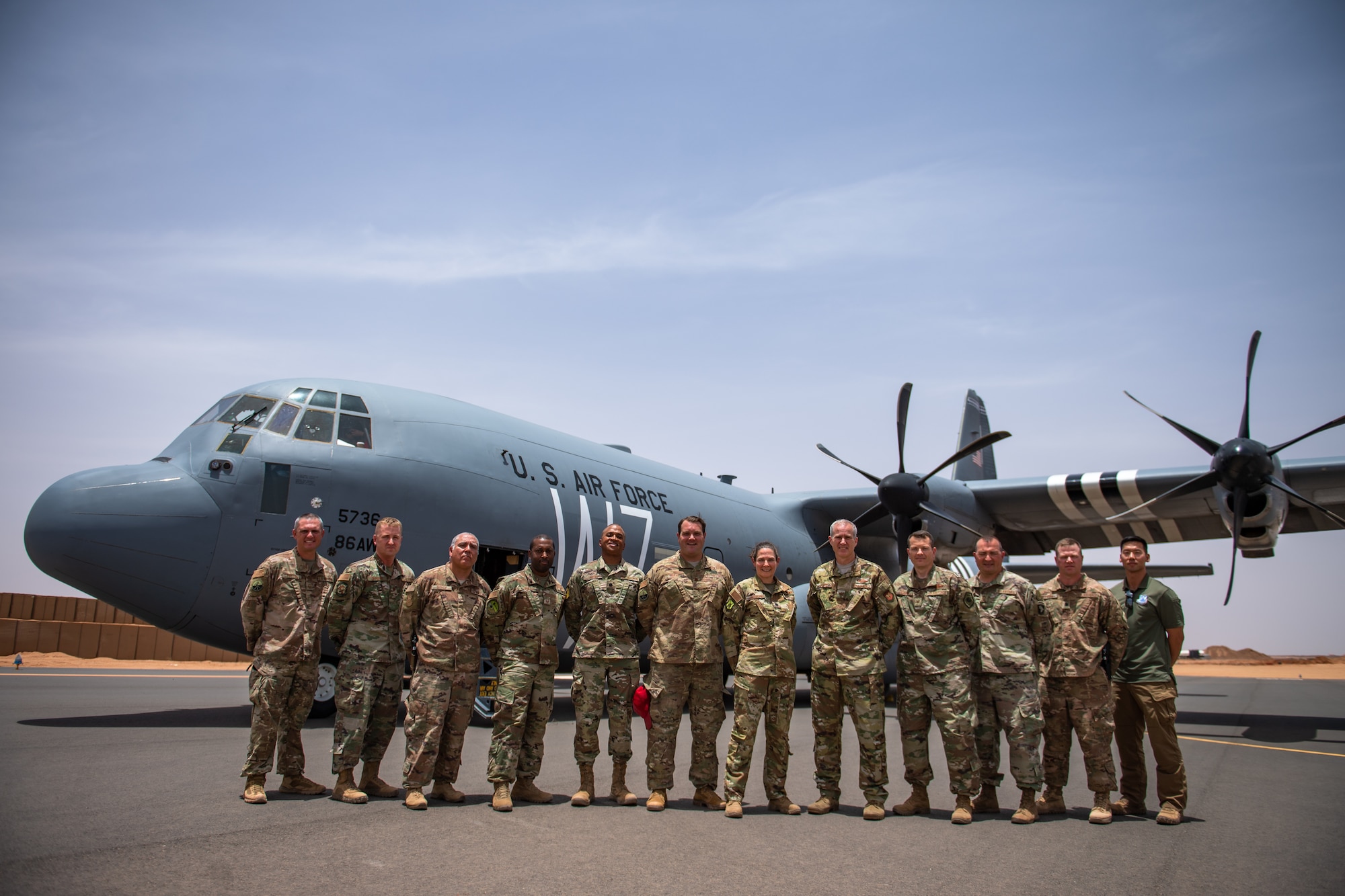 U.S. Air Force leadership from the 435th Air Expeditionary Wing and the 409th Air Expeditionary Group pose for a photo in front of a C-130J Super Hercules at Nigerien Air Base 201, Agadez, Niger, Aug. 3, 2019. This was the first C-130 to land at Air Base 201, marking the beginning of limited Visual Flight Rules operations at the base. (U.S. Air Force photo by Staff Sgt. Devin Boyer)