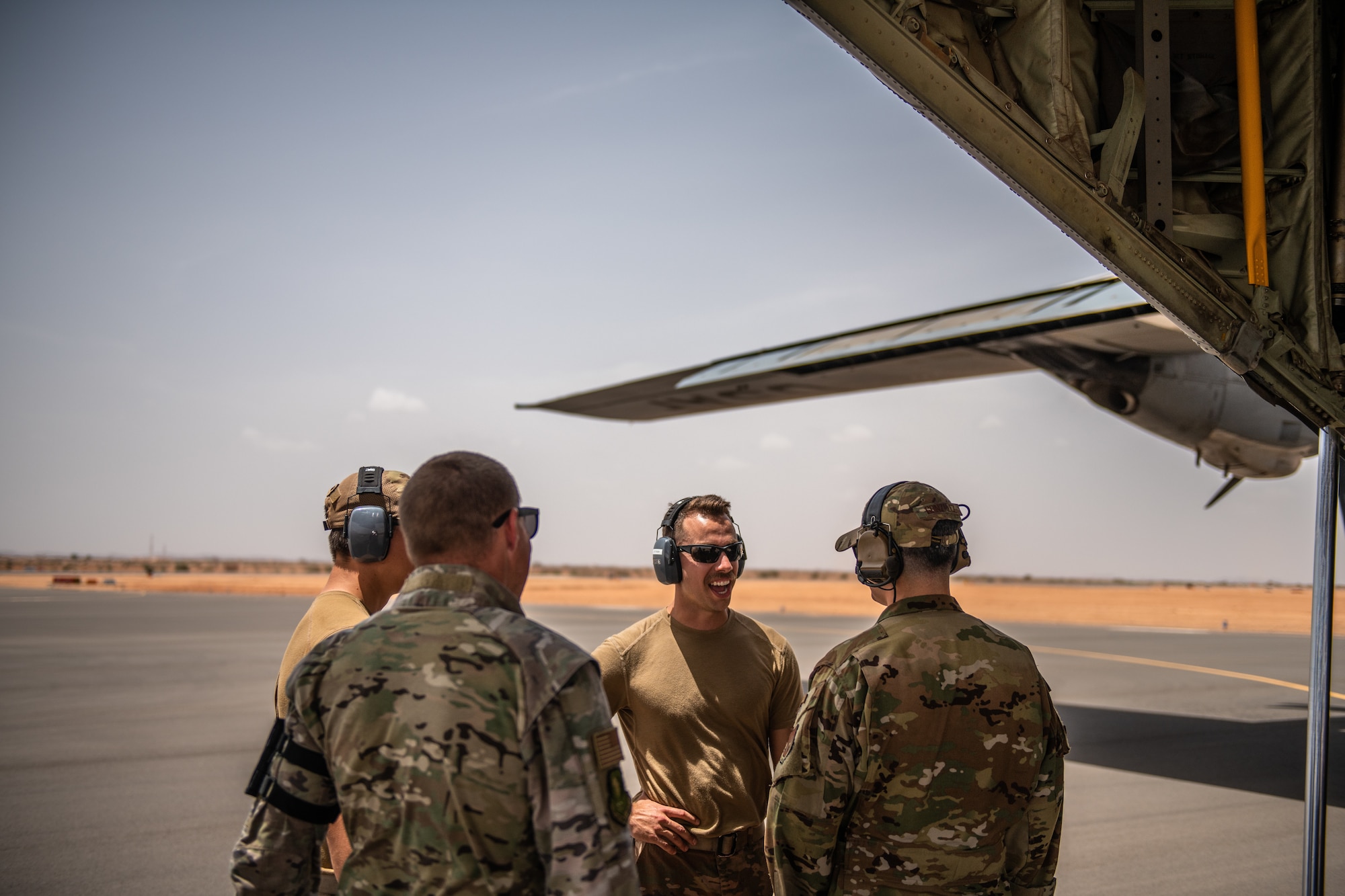 U.S. Air Force Airmen assigned to the 724th Expeditionary Air Base Squadron converse after the first military aircraft landing at Nigerien Air Base 201, Agadez, Niger, Aug. 3, 2019. The landing marked the next step in airfield evaluations by starting Visual Flight Rules operations at the base. (U.S. Air Force photo by Staff Sgt. Devin Boyer)