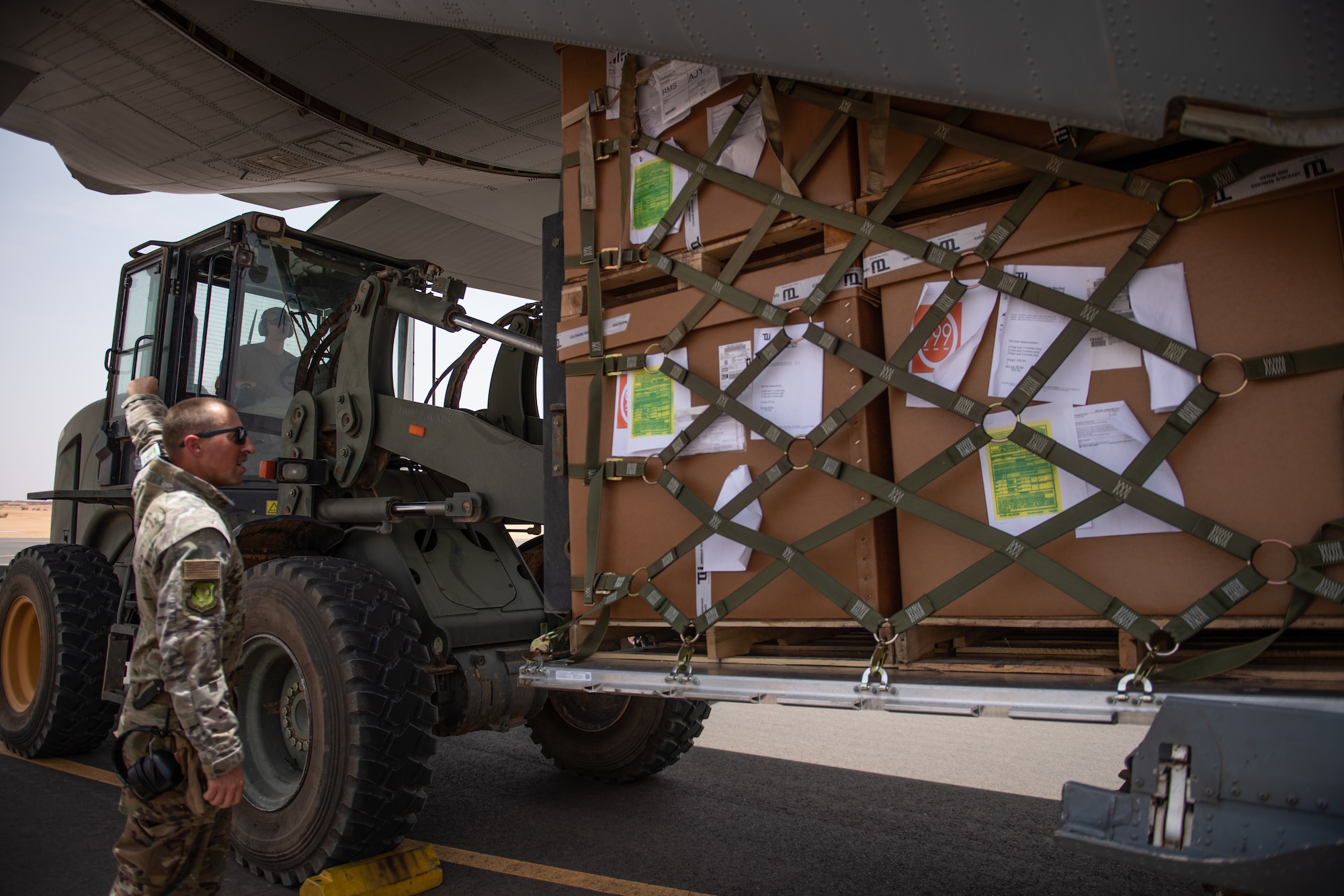 U.S. Air Force Senior Airman Steven Roy, 724th Expeditionary Air Base Squadron air terminal operations center information controller, directs Staff Sgt. Dustin Cote, 724th EABS ATOC technician, while loading a C-130J Super Hercules at Nigerien Air Base 201, Agadez, Niger, Aug. 3, 2019. This was the first C-130 to take-off at Air Base 201, marking the beginning of limited Visual Flight Rules operations at the base. (U.S. Air Force photo by Staff Sgt. Lexie West)