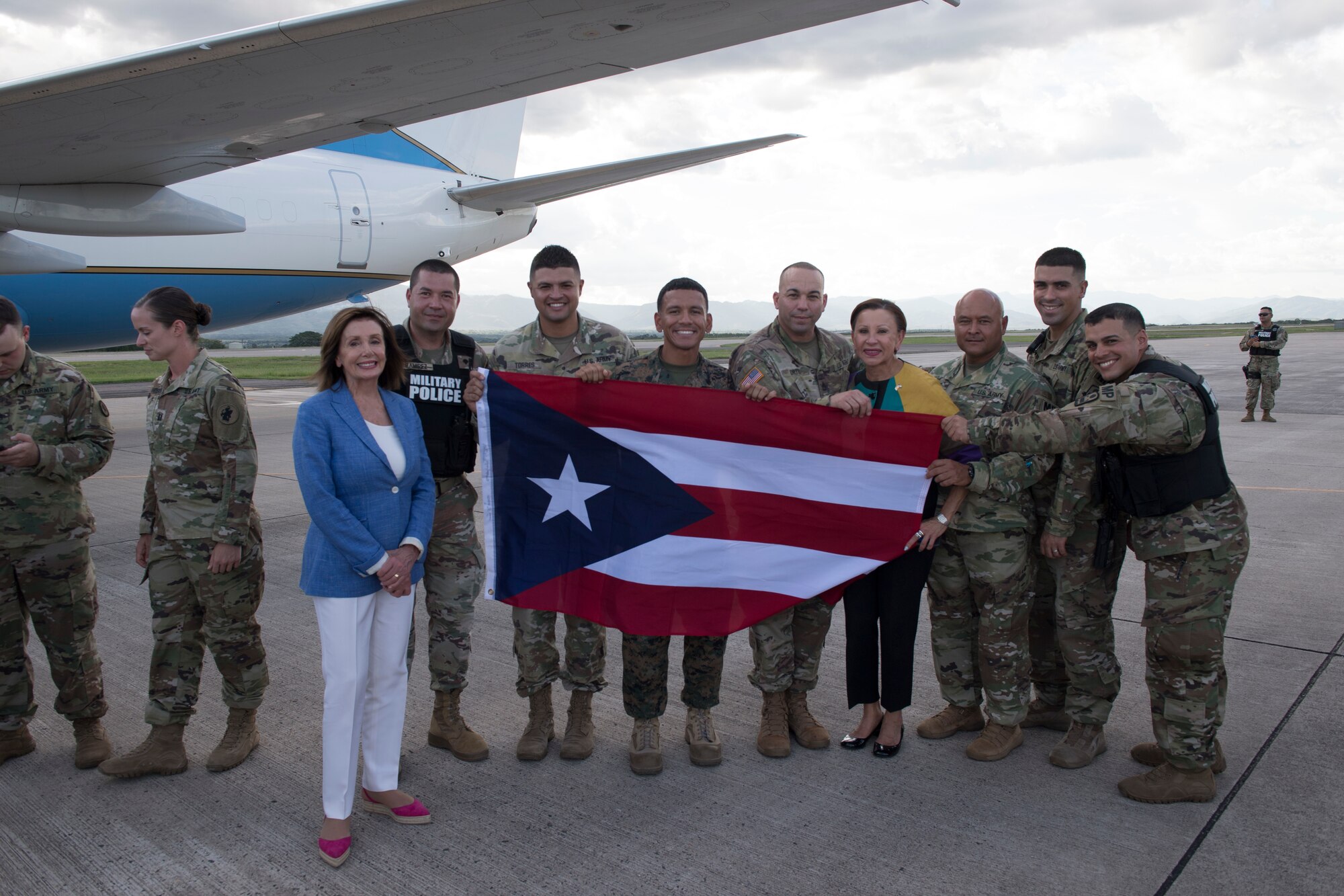 Service members from Puerto Rico pose with congressional representative and Speaker of the U.S. House of representatives, Aug. 10, 2019, at Soto Cano Air Base Honduras. Representatives from various states visited service members during a visit to Honduras, accompanying the Speaker of the House Nancy Pelosi..