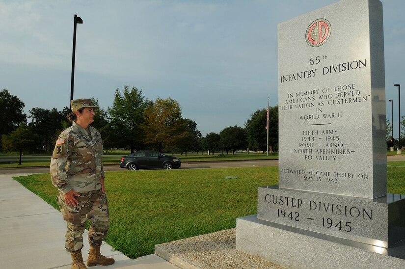 Brig. Gen. Kris A. Belanger, Commanding General, 85th U.S. Army Support Command, reflects on the command’s lineage while looking at a monument at Camp Shelby, Mississippi, honoring the World War II Soldiers of the, then, 85th Infantry Division which fought overseas during World War II.