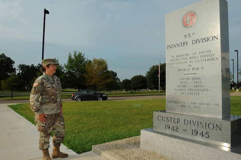 Brig. Gen. Kris A. Belanger, Commanding General, 85th U.S. Army Support Command, reflects on the command’s lineage while looking at a monument at Camp Shelby, Mississippi, honoring the World War II Soldiers of the, then, 85th Infantry Division which fought overseas during World War II.