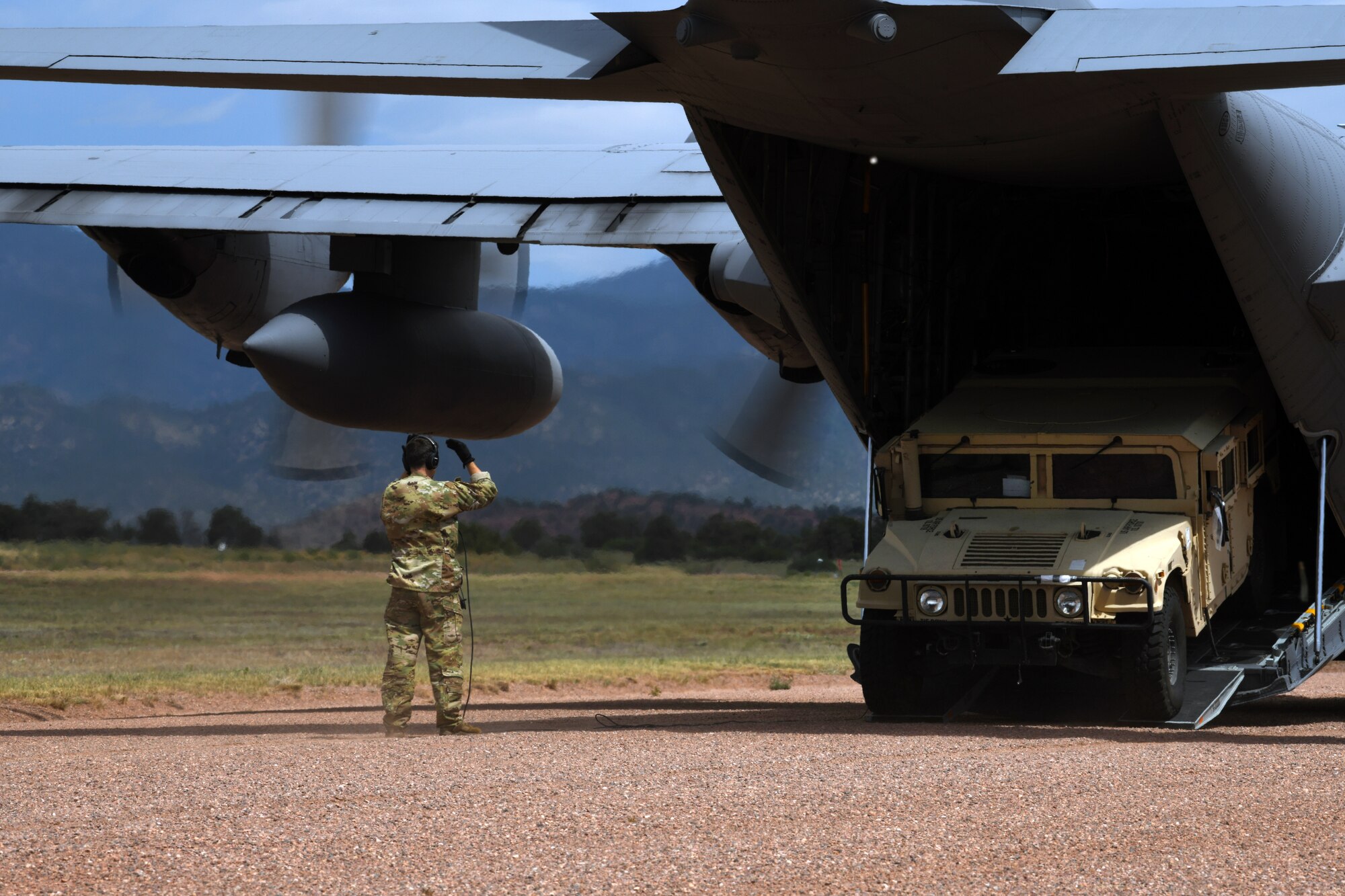 Airmen from the 302nd Airlift Wing aid the 13th Air Support Operations Squadron get through mission qualification training by practicing a contingency scenario landing and unloading of a C-130 Hercules July 17, 2019 on Fort Carson, Colorado. The C-130 was carrying tactical air control party Airmen, a Humvee and supplies for the exercise.  (U.S. Air Force photo by Airman 1st Class Andrew Bertain)