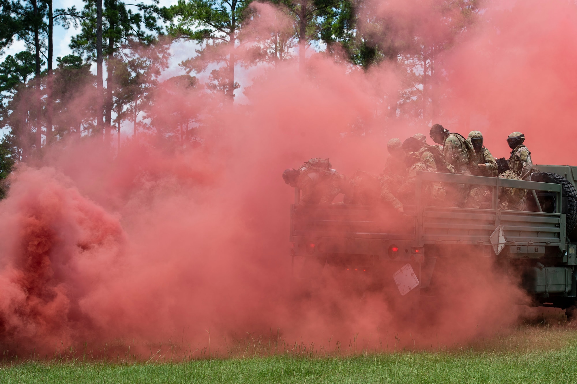 Airmen from the 824th Base Defense Squadron move through red smoke during the Tactical Leaders Course, Aug. 10, 2019, at Moody Air Force Base, Ga. The 7-day course revolved around squad leaders developing their skills to effectively communicate, team build and mission plan. These skills were assessed during a 36-hour simulated operation where squad leaders lead Airmen through tactical situations. (U.S. Air Force photo by Airman Azaria E. Foster)