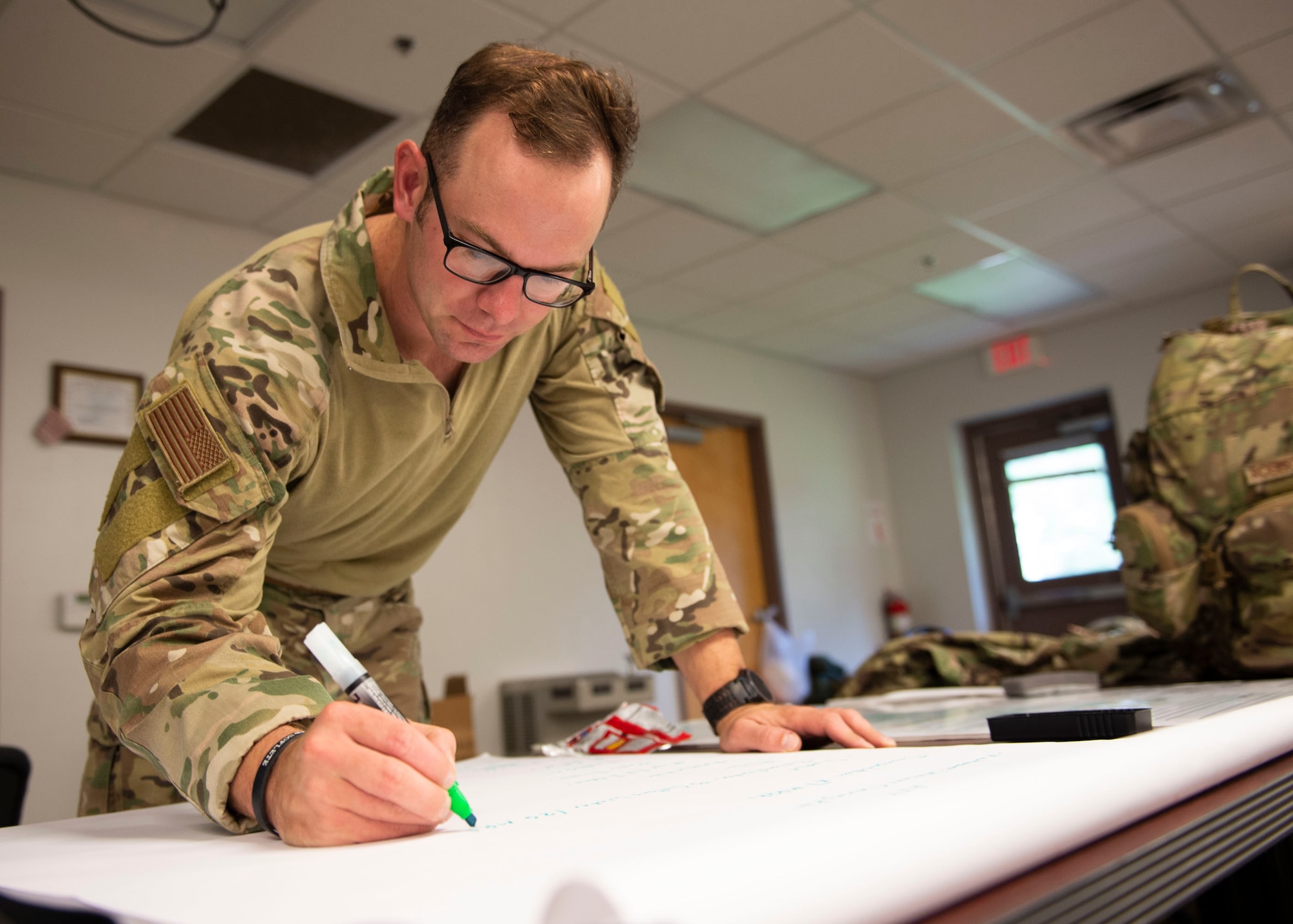 Staff Sgt. Neil Stuart, 824th Base Defense Squadron squad leader, writes down training exercise plans during the Tactical Leaders Course, Aug. 10, 2019, at Moody Air Force Base, Ga. The 7-day course revolved around squad leaders developing their skills to effectively communicate, team build and mission plan. These skills were assessed during a 36-hour simulated operation where squad leaders lead Airmen through tactical situations. (U.S. Air Force photo by Airman Azaria E. Foster)