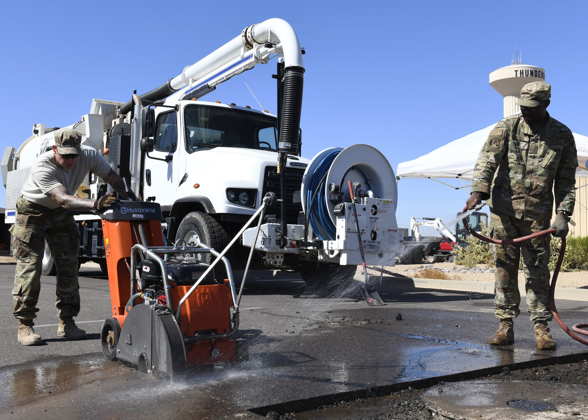 Staff Sgt. Robert Newton (left) and Tech. Sgt. Ronnie Jamison (right), 56th Civil Engineering Squadron pavements and heavy equipment operators, use an asphalt road cutter to remove chunks of asphalt Aug. 12, 2019, at Luke Air Force Base, Ariz.