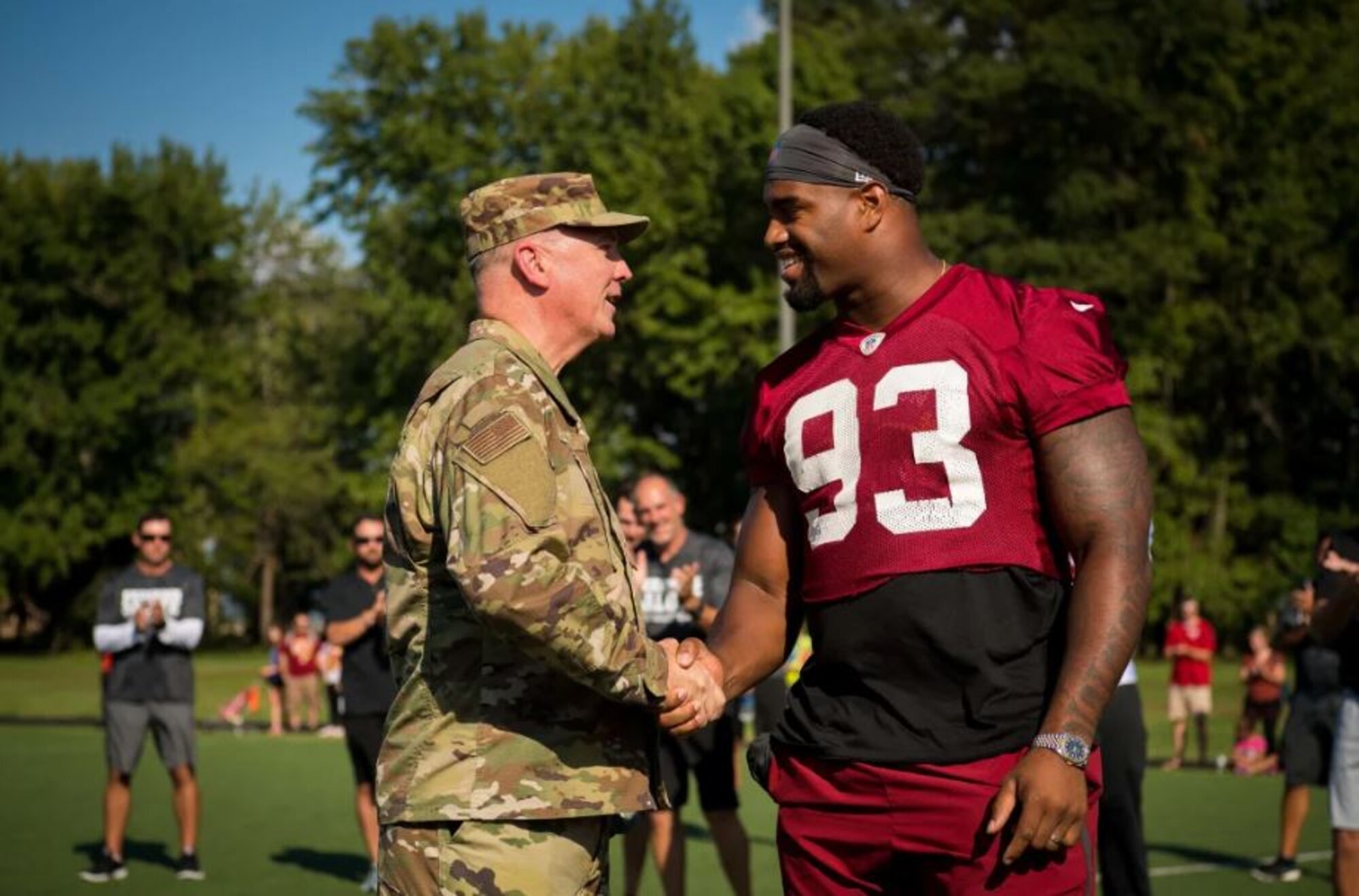 Air Force District of Washington Commander Maj. Gen. Ricky N. Rupp shakes hands with Washington Redskins defensive end Jonathan Allen Aug. 14. The team held a special walkthrough practice at Joint Base Andrews as part of ongoing Redskins Salute efforts presented by USAA.(Courtesy photo/Washington Redskins)