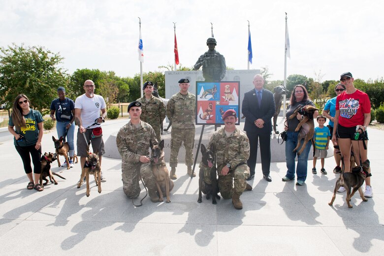 U.S. Air Force members, Robert Carr (center), Post Master of San Antonio, and local volunteers of the K-9 program pose for a photo during the Military Working Dog Stamp ceremony Aug. 15, 2019, at Joint Base San Antonio-Medina Annex, Texas.