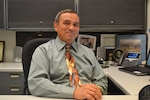 DLA NESO Senior Operations Research Analyst Mark Melius sits at his desk.
