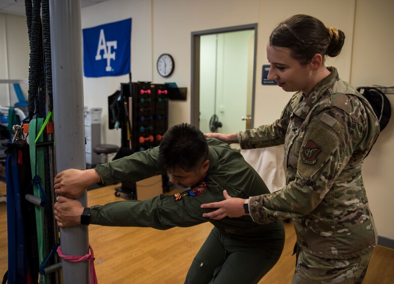 U.S. Air Force Staff Sgt. Michaela Chevalier, 8th Medical Operations Squadron physical therapy technician, teaches a pilot from Republic of Korea Air Force’s 111th Fighter Squadron how to stretch his back, during a training session at Kunsan Air Base, Republic of Korea, Aug. 9, 2019. Pilots often suffer from neck and back pain from flying for prolonged hours wearing their equipment. (U.S. Air Force photo by Senior Airman Stefan Alvarez)