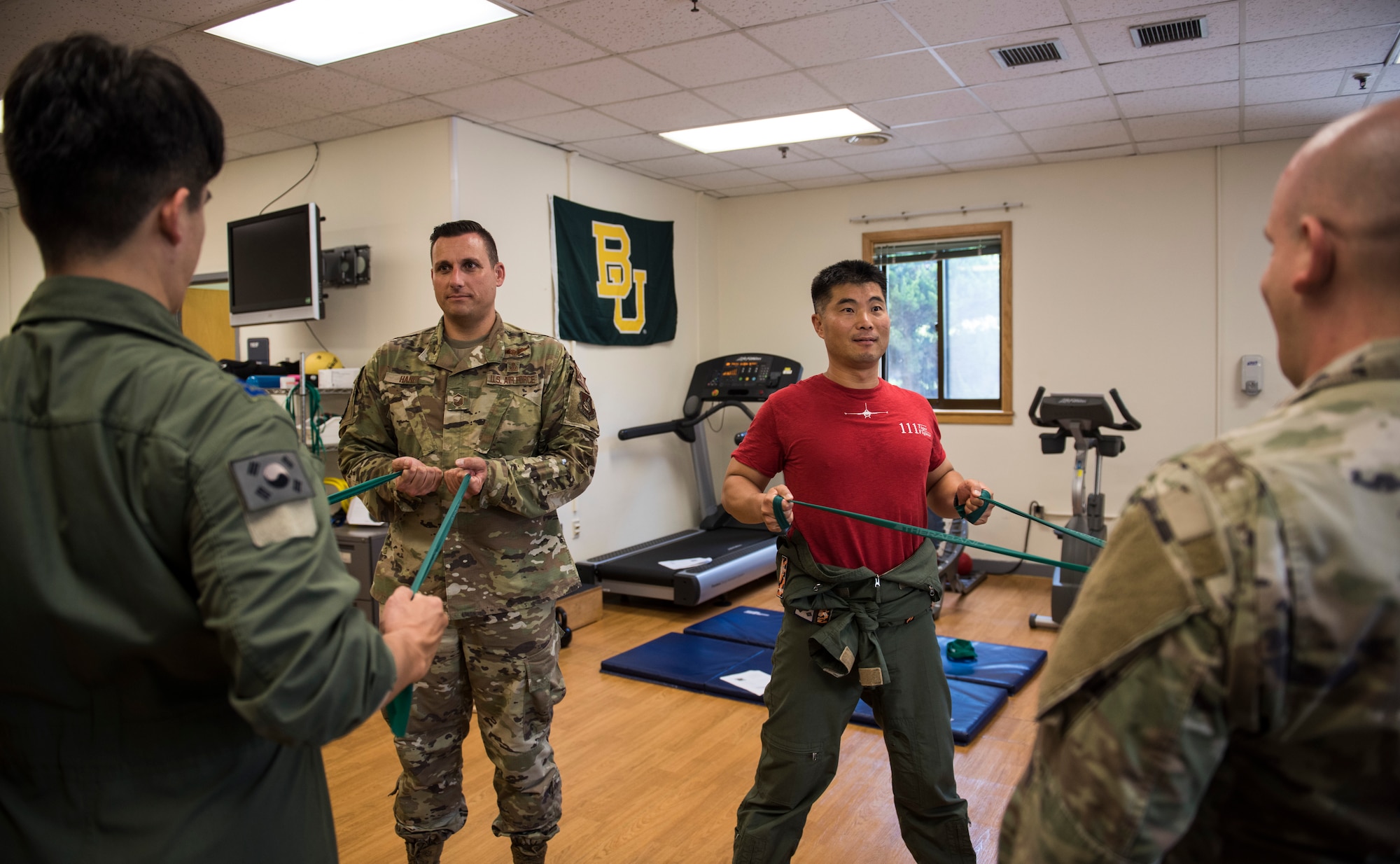 U.S. Air Force Tech. Sgt. Nicholas Ramirez (far right), 8th Medical Operations Squadron physical therapy flight chief, and Master Sgt. Joshua Haney (middle left), 8th Medical Operations Squadron superintendent, teach pilots from Republic of Korea Air Force’s 111th Fighter Squadron how to stretch their backs during a training session at Kunsan Air Base, Republic of Korea, Aug. 9, 2019. Pilots often find themselves developing pain in different areas from regularly putting their bodies under high amounts of gravitational forces. (U.S. Air Force photo by Senior Airman Stefan Alvarez)