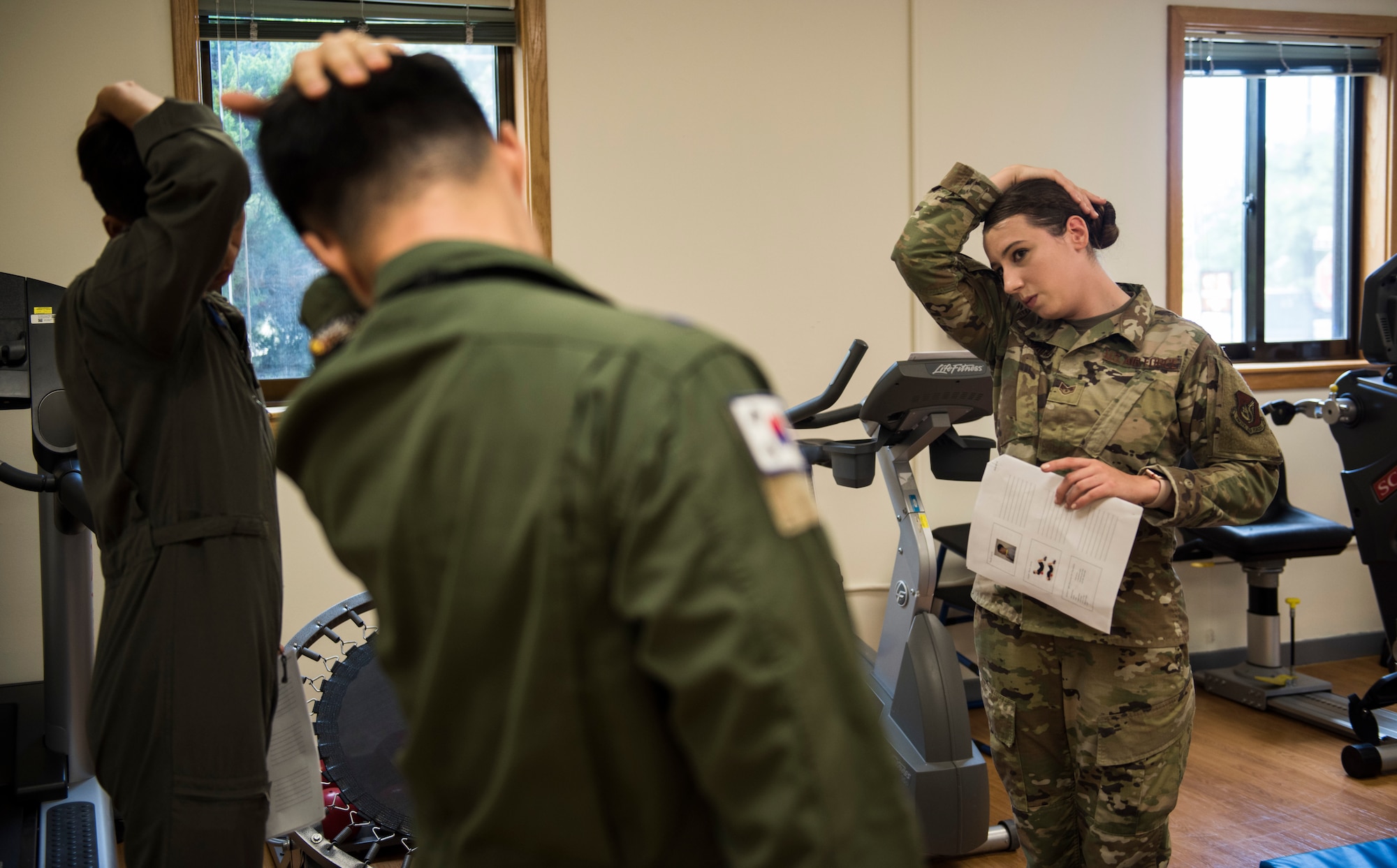 U.S. Air Force Staff Sgt. Michaela Chevalier, 8th Medical Operations Squadron physical therapy technician, teaches pilots from Republic of Korea Air Force’s 111th Fighter Squadron how to stretch their necks during a training session at Kunsan Air Base, Republic of Korea, Aug. 9, 2019. Pilots often suffer from neck and back pain from flying for prolonged hours wearing their equipment. (U.S. Air Force photo by Senior Airman Stefan Alvarez)