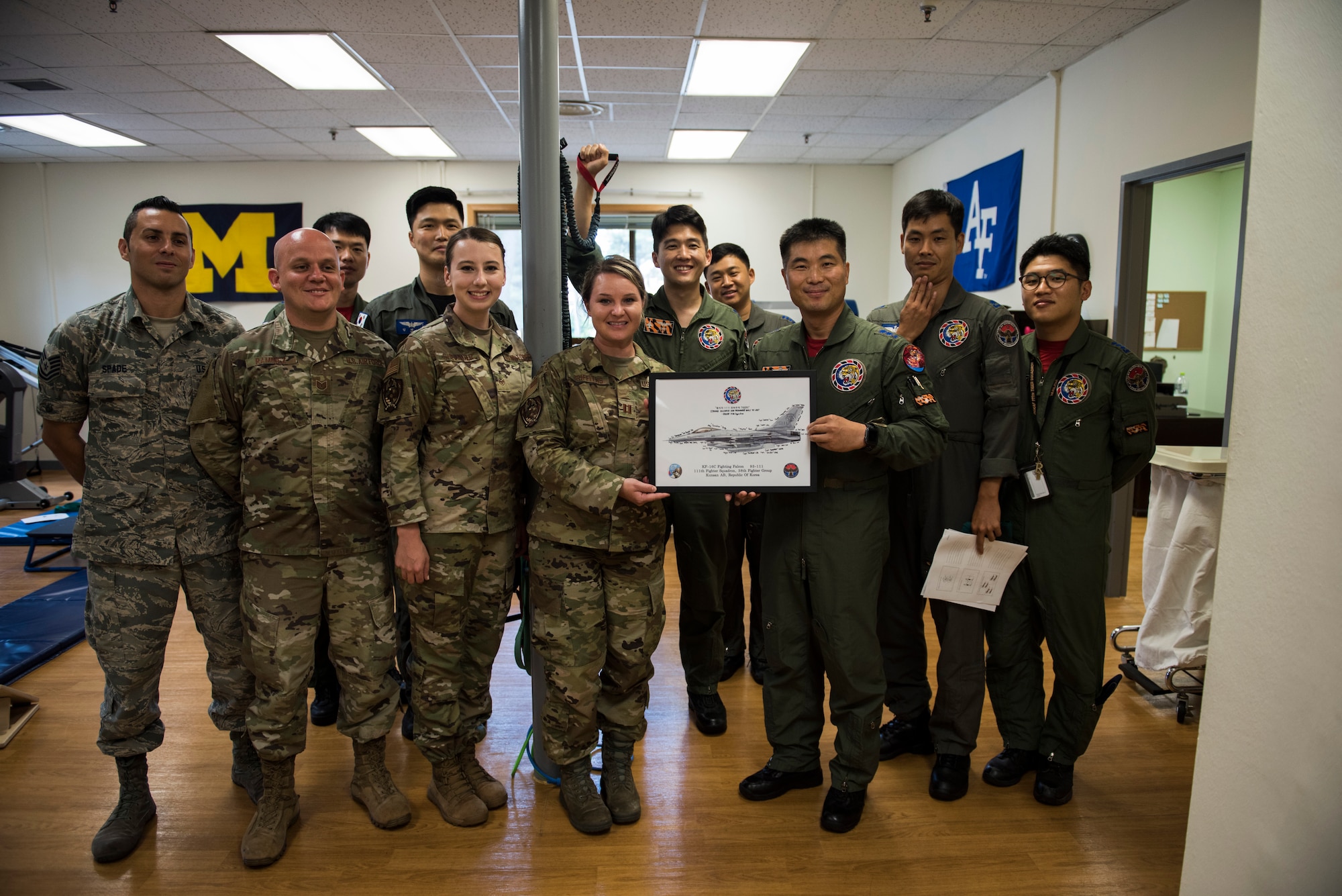 The 8th Medical Operations Squadron physical therapy flight poses with a picture with pilots from the Republic of Korea Air Force’s 111th Fighter Squadron after a training session at Kunsan Air Base, Republic of Korea, Aug. 09, 2019. The 8th MDOS physical therapy flight taught the 111th FS pilots how to perform various stretches and exercises to alleviate pain and discomfort they were having. (U.S. Air Force photo by Senior Airman Stefan Alvarez)