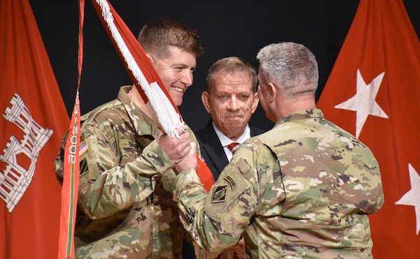 Maj. Gen. Richard Kaiser, right, deputy chief of engineers and deputy commanding general of the U.S. Army Corps of Engineers, presents the Huntsville Center’s guidon to Col. Marvin Griffin, as Albert "Chip" Marin III, Huntsville Center programs director looks on.