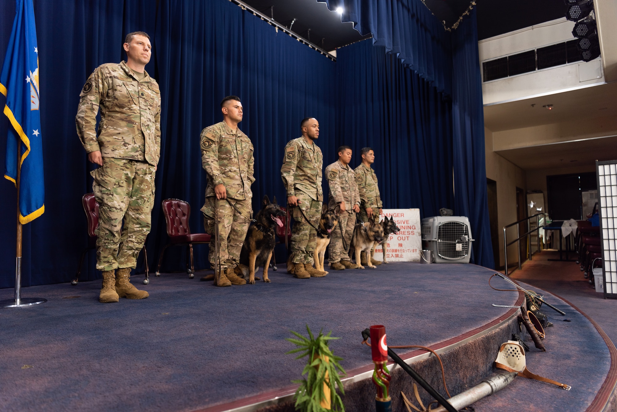 U.S. Air Force military working dog (MWD) handlers assigned to the 18th Security Forces Squadron stand by their MWDs during a MWD retirement ceremony July 26, 2019, on Kadena Air Base, Japan. MWDs and their handlers must have trust and patience with one another to work together as a team and accomplish the mission safely and effectively. (U.S. Air Force photo by Senior Airman Cynthia Belío)