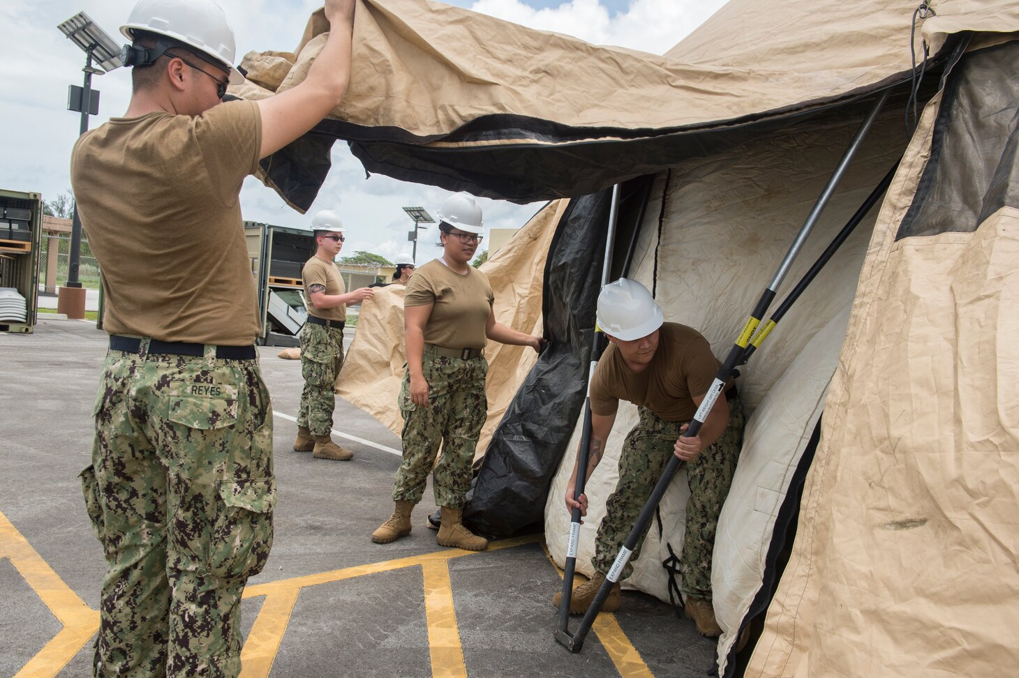 SANTA RITA, Guam (Aug. 12, 2019) Reserve Sailors assigned to Navy Expeditionary Forces Command Pacific (NEFCPAC), adjust the legs of a tent in preparation for integrated training during an integrated training evolution. Active duty and reserve components assigned to NEFCPAC, work together to execute operational command and control of assigned and attached Navy Expeditionary Combat Forces in the U.S. 7th Fleet area of operations and serve as the core Navy battle staff for crisis response and major combat operations.