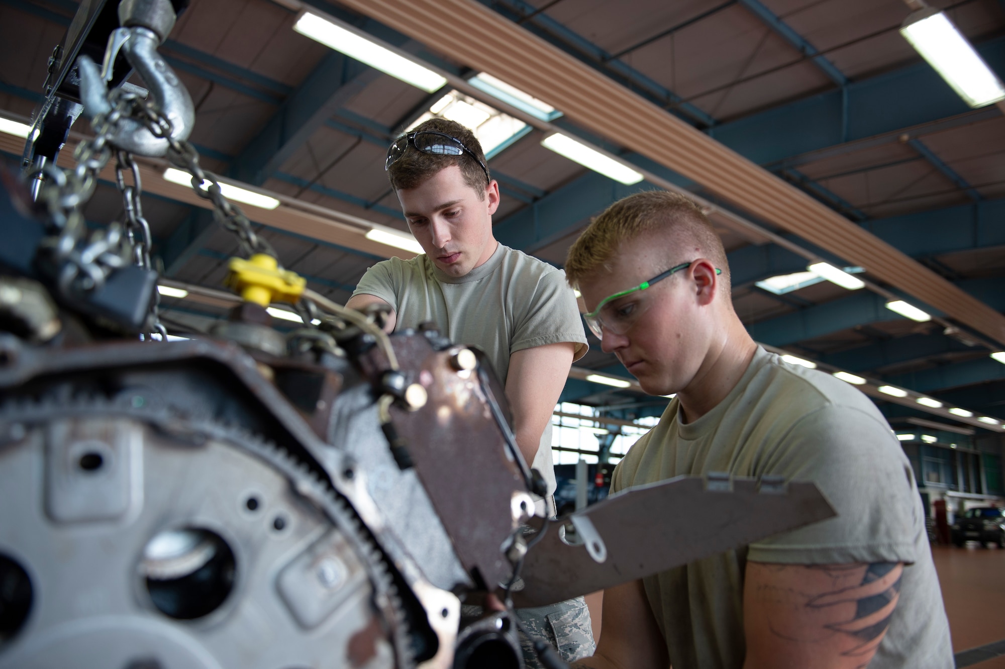 U.S. Air Force Airmen 1st Class Colin Coogan and Dustin Carter, 52nd Logistics Readiness Squadron vehicle management journeymen, perform maintenance on a Humvee engine at Spangdahlem Air Base, Germany, Aug. 7, 2019.