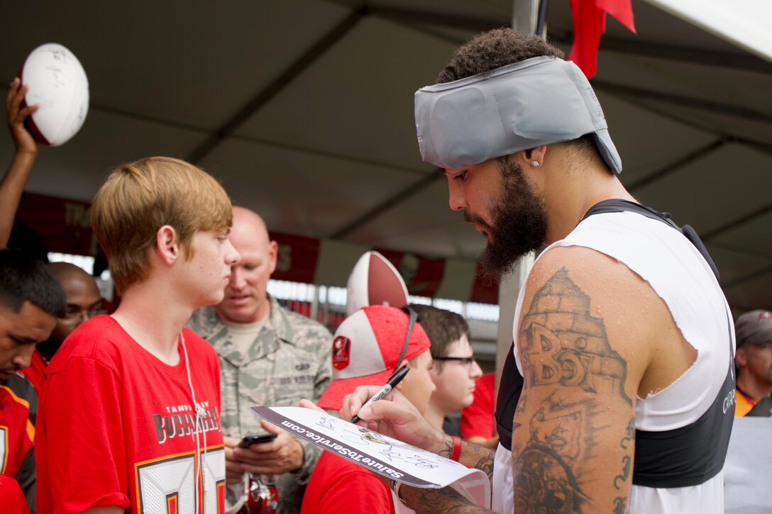 Michael Lynn Evans III, American football wide receiver for the Tampa Bay Buccaneers autographs memorabilia for fans on August 5 at the AdventHealth Training Center in Tampa. During the Military Day-Training Camp service members and their families were able to watch and meet the Tampa Bay Buccaneer players. (U.S. Air Force Photo by Senior Airman Alexis Suarez) 190805-F-CG206-0065