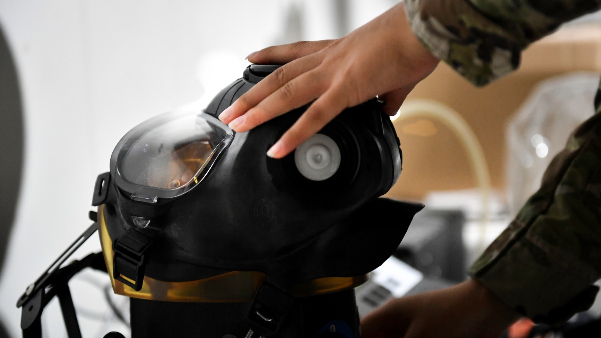 Airman 1st Class Brianna Renninger, 386th Expeditionary Logistics Readiness Squadron expeditionary theater distribution center journeyman, tests an M-50 joint service general purpose mask, at a theater distribution center on Ali Al Salem Air Base, Kuwait, Aug. 13, 2019. The masks are tested for marks, scratches and broken seals that would render the mask ineffective in an emergency situation. (U.S. Air Force photo by Staff Sgt. Mozer O. Da Cunha)