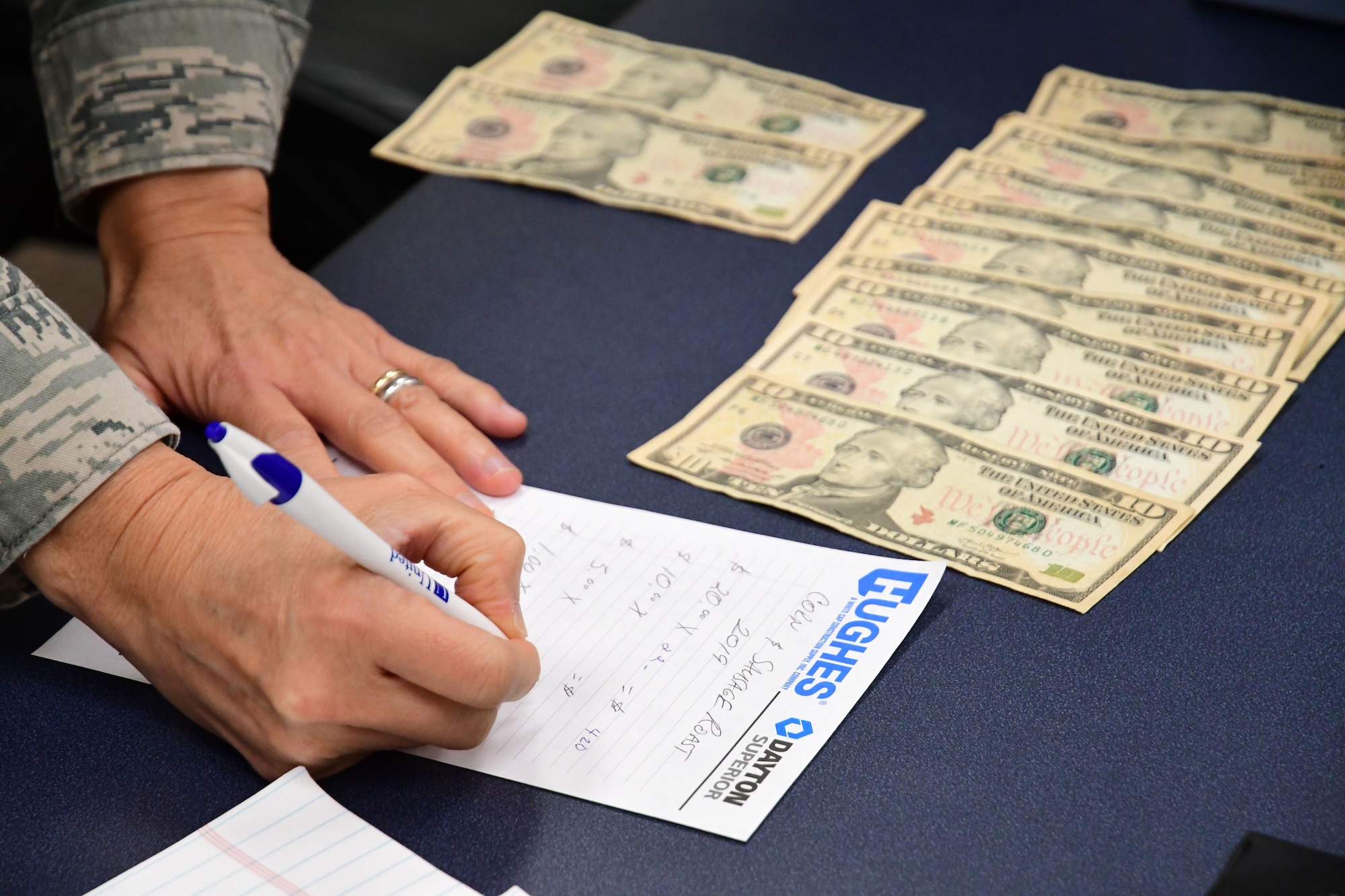 Capt. Anna Sanchez, 94th Airman and Family Readiness representative, counts proceeds from this year's Corn and Sausage Roast Fundraiser at Dobbins Air Reserve Base, Ga., Aug. 15, 2019.