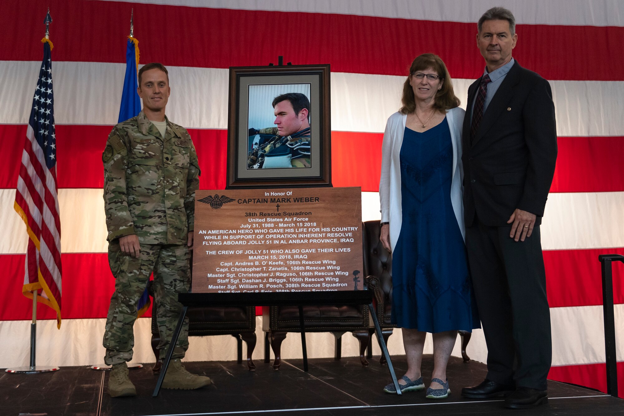 Lt. Col. Jason Egger, left, 38th Rescue Squadron (RQS) commander, and Ron and Marge Weber, right, parents of Capt. Mark Weber, pose for a photo during a dedication ceremony Aug. 16, 2019, at Moody Air Force Base, Ga. The event room in building 400 at Moody was dedicated to and renamed in honor of Capt. Mark Weber, 38th RQS combat rescue officer. Weber, a Texas native, was killed in an HH-60G Pave Hawk crash in Anbar Province, Iraq, March 15, 2018, while supporting Operation Inherent Resolve. (U.S. Air Force photo by Airman 1st Class Taryn Butler)