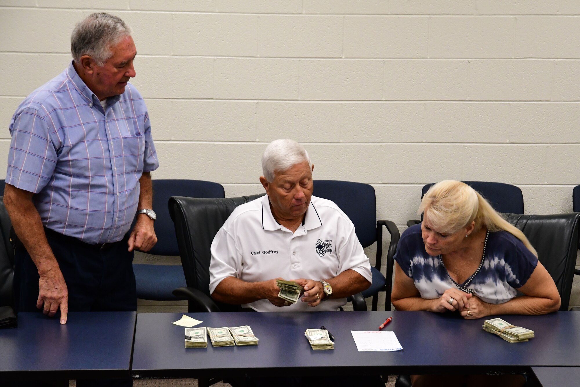 Square and Compass Club members count proceeds from this year's Corn and Sausage Roast fundraiser at Dobbins Air Reserve Base, Ga., Aug. 15, 2019.