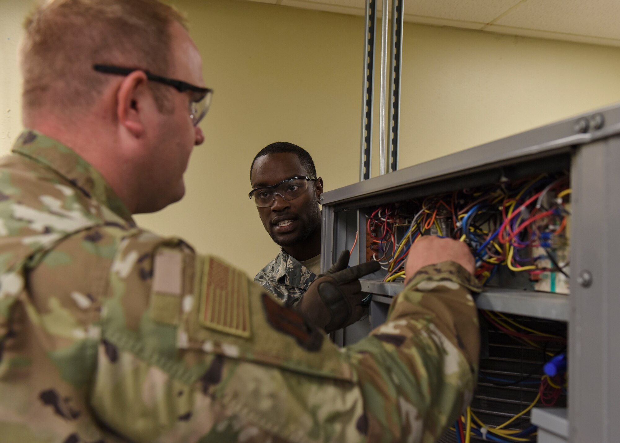 Staff Sgt. Tamerick McGhee (center) and Staff Sgt. Trevor Krcil (left), 366th Training Squadron HVAC/R craftsman course students, ensure a ventilation system is properly regulating heat and cool air at Sheppard Air Force Base, Texas, Aug. 14, 2019. Upon completing their 5-level certifications, HVAC technicians worldwide return to Sheppard to continue their job development and achieve their 7-level certification. (U.S. Air Force photo by Senior Airman Ilyana A. Escalona)