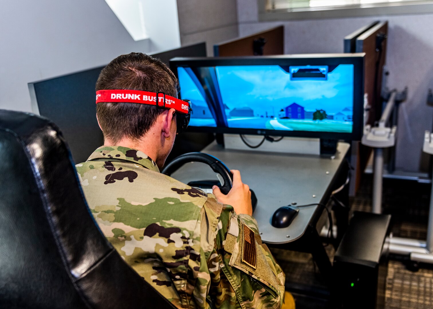 Man sitting at a game console that simulates the effects of impaired driving.