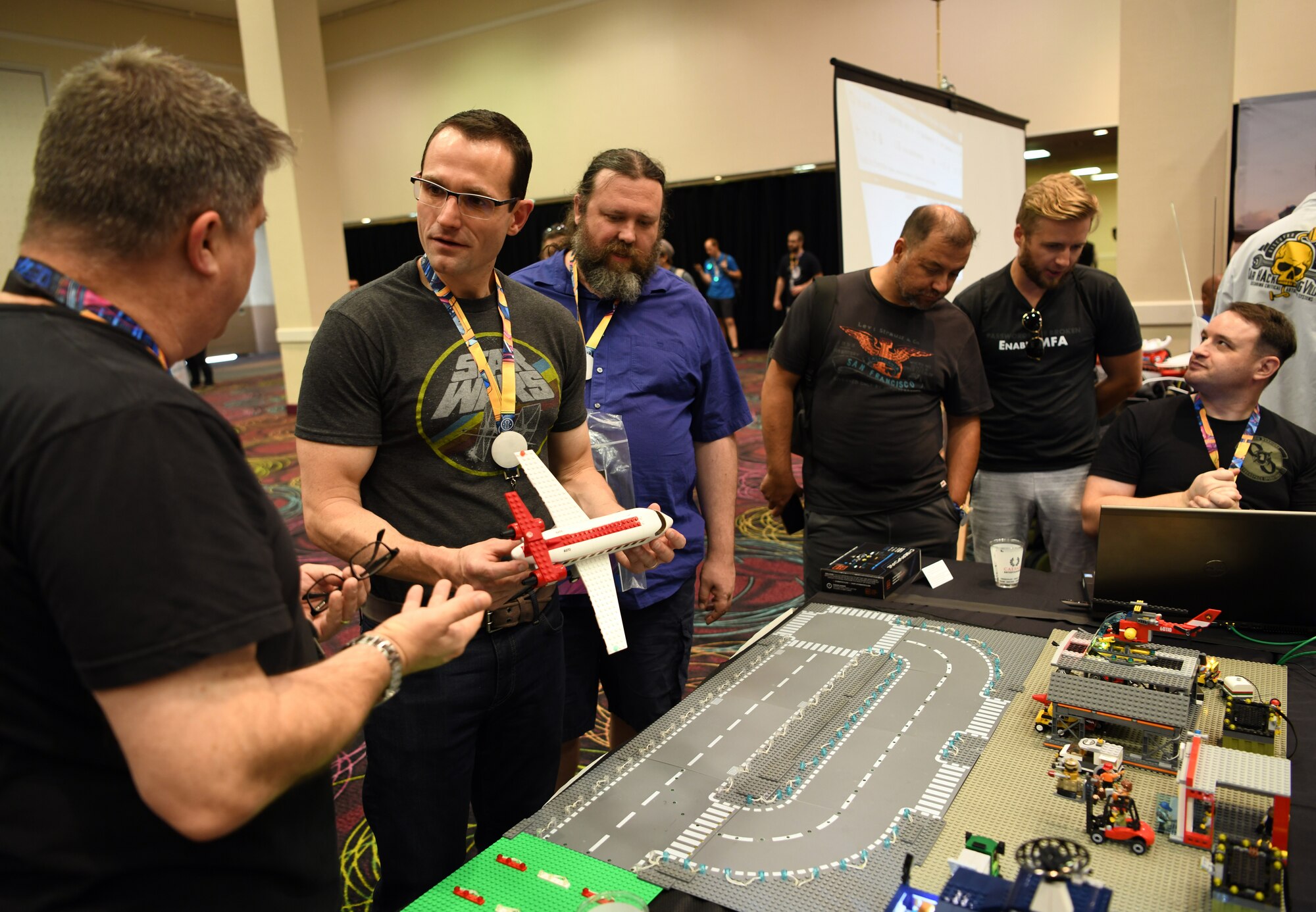 Scott Thompson, 90th Cyberspace Operations Squadron, systems engineer, hosts Dr. Will Roper, Assistant Secretary of the Air Force for Acquisition, Technology and Logistics, for a “Bricks in the Loop” presentation at DEF CON 27 Hacking Conference in Las Vegas, Aug. 9, 2019. “Bricks in the Loop” mimics an Air Force installation to simulate real-world cyber systems in training cyber operators. (U.S. Air Force photo by Tech. Sgt. R.J. Biermann)