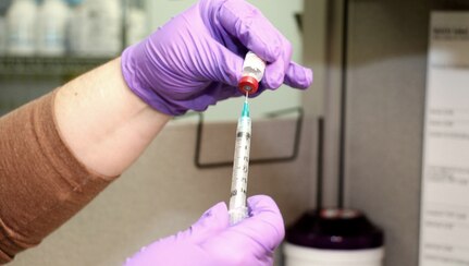 Pharmacist Angelina Cox prepares a dose of shingles vaccine to administer to a TRICARE beneficiary.