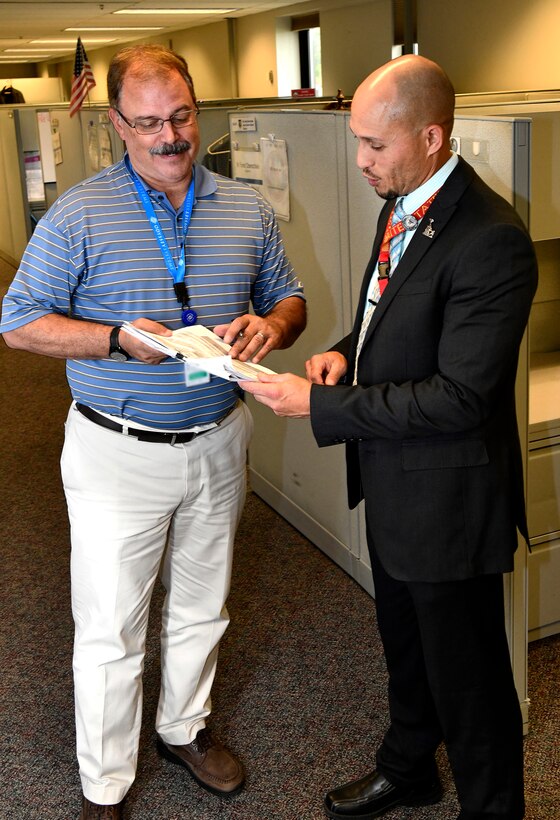 Rey Febo discusses strategic planning for capabilities and risks with a coworker at Wright-Patterson Air Force Base, August 13 2019.  (U.S. Air Force photo / Darrius A. Parker)