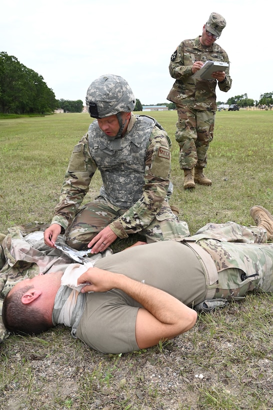 Tech. Sgt. Jeremy Levenhagen, of the 119th Medical Group applies medical treatment to a simulated injury victim as instructor Staff Sgt. Colton Belmore, of the N.D. Army National Guard, evaluates him during Tactical Combat Casualty Care (TCCC) training at Camp Gilbert C. Grafton, N.D., Aug. 9, 2019.