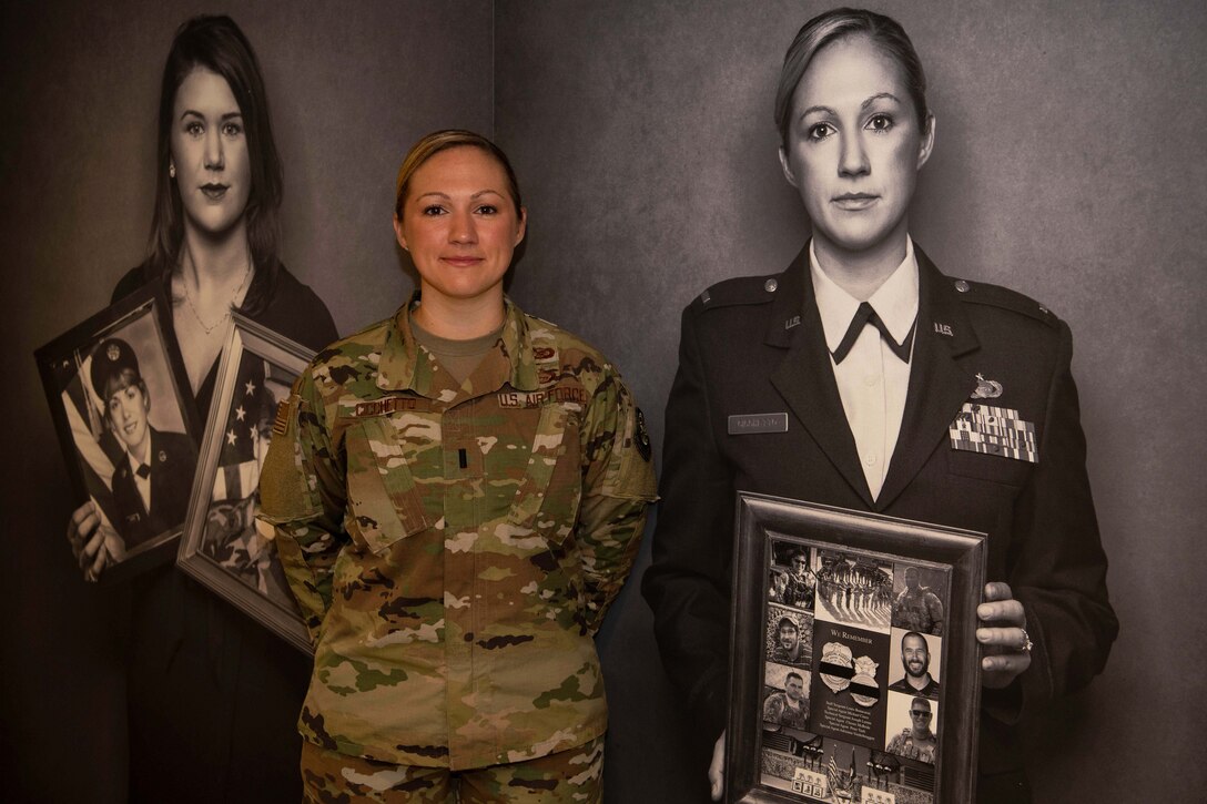 A woman poses next to a black-and-white photo of herself.