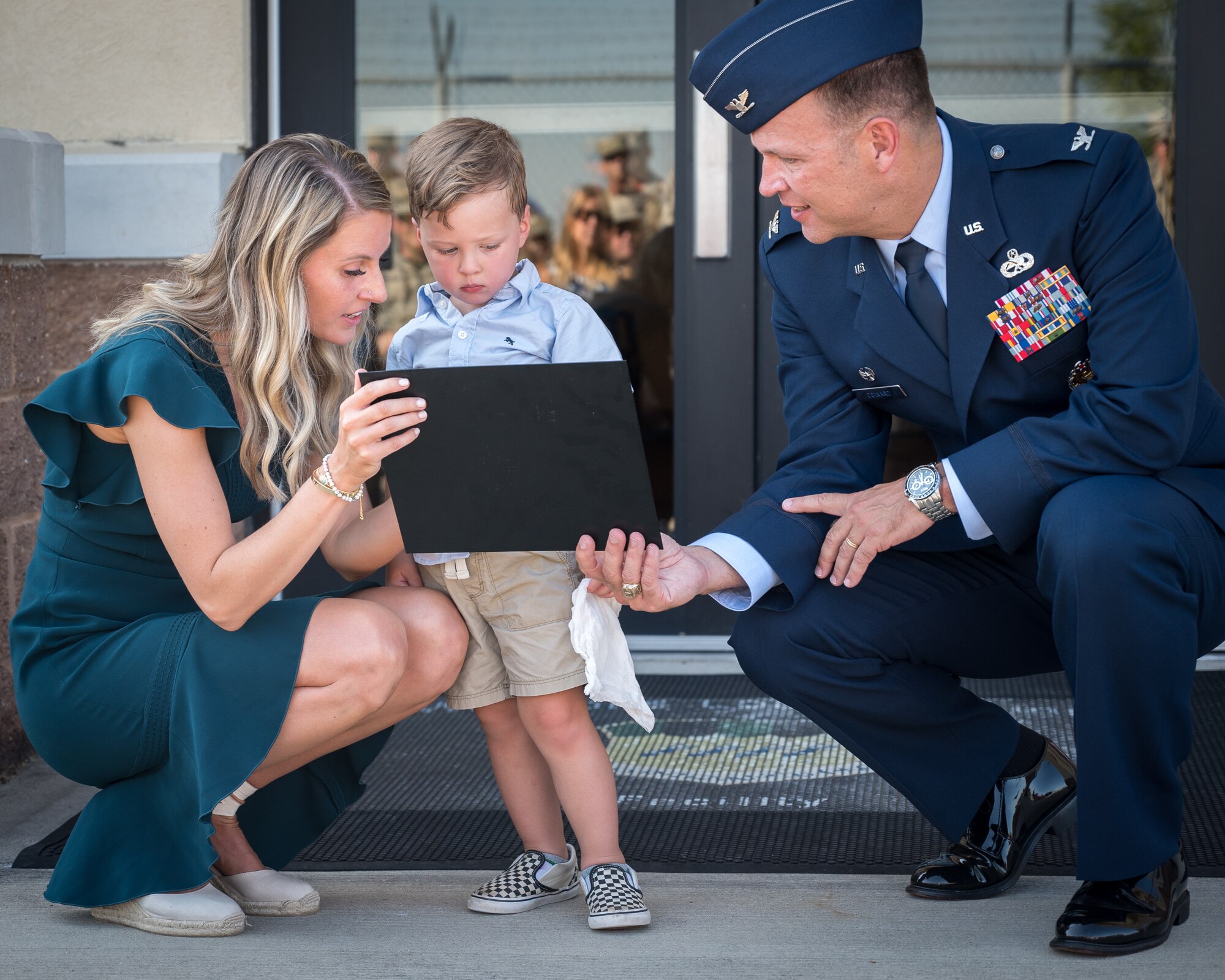Alyssa Kidd and Beckham Kidd receive a replica of the plaque from Col. Michael Colvard, 2nd Maintenance Group commander, of what will go onto the newly named Kidd Weapons Load Training facility in honor of the late Tech. Sgt. Joshua L. Kidd Aug. 16, 2019, Barksdale Air Force Base, Louisiana.