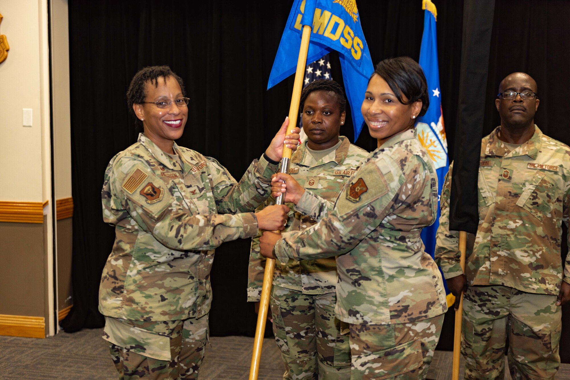 Lt. Col. Cynthia K. McGee, commander of the newly established 509th Healthcare Operations Squadron, ceremoniously returns the guide-on of the now inactivated 509th Medical Support Squadron to Col. Chrystal D. Henderson, commander of the 509th Medical Group, during a reorganization ceremony Aug. 14, 2019, at Whiteman Air force Base, Mo. Under the new Air Force Medical Reform model, dedicated provider care teams will be aligned to an Operational Medical Readiness Squadron primarily focused on proactively treating active-duty Airmen and improving their availability to support the warfighting mission. Care for non-active duty patients, primarily the families of service members and military retirees, will be handled by separate provider teams aligned to a Health Care Operations Squadron. (U.S. Air Force photo by Senior Airman Thomas Barley)