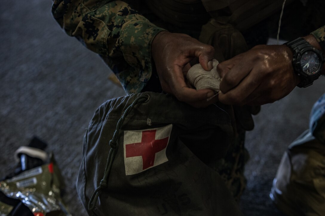 A Navy Corpsman with Combat Logistics Battalion 31, 31st Marine Expeditionary Unit, provides aid to a simulated casualty during a casualty evacuation exercise aboard the amphibious assault ship USS Wasp (LHD 1), underway in the Philippine Sea, June 12, 2019. The 31st Marine Expeditionary Unit, the Marine Corps` only continuously forward-deployed MEU, provides a flexible and lethal force ready to perform a wide range of military operations as the premier crisis response force in the Indo-Pacific region. (Official U.S. Marine Corps photo by Cpl. Isaac Cantrell)