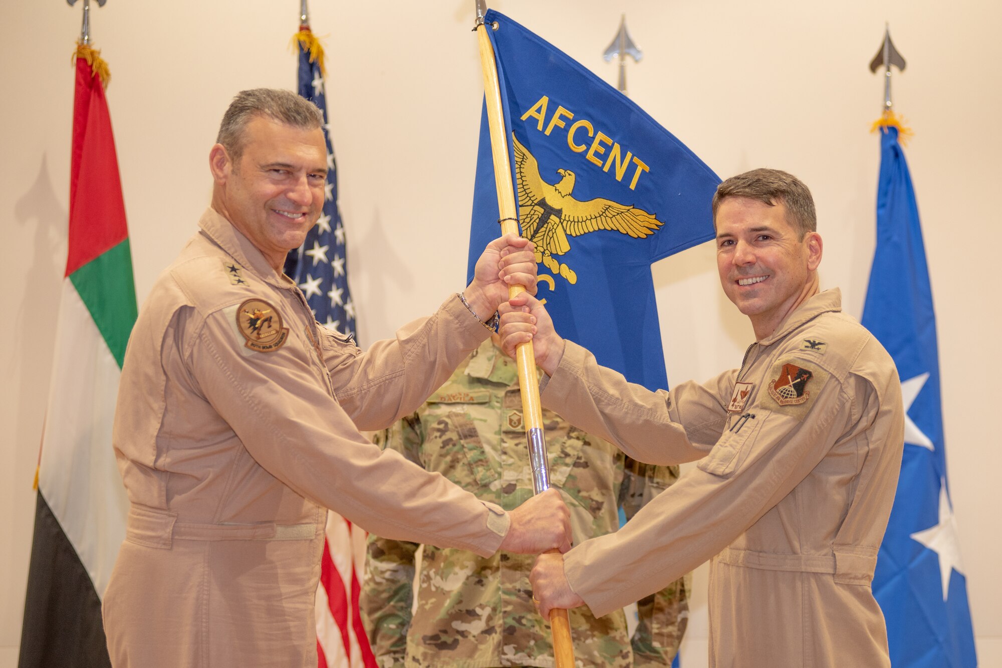 Col. Thomas Wolfe, right, accepts command of the Air Warfare Center by taking the guidon to Lt. Gen. Joseph T. Guastella, U.S. Air Force Central Command commander, June 19, 2019, at Al Dhafra Air Base, United Arab Emirates.