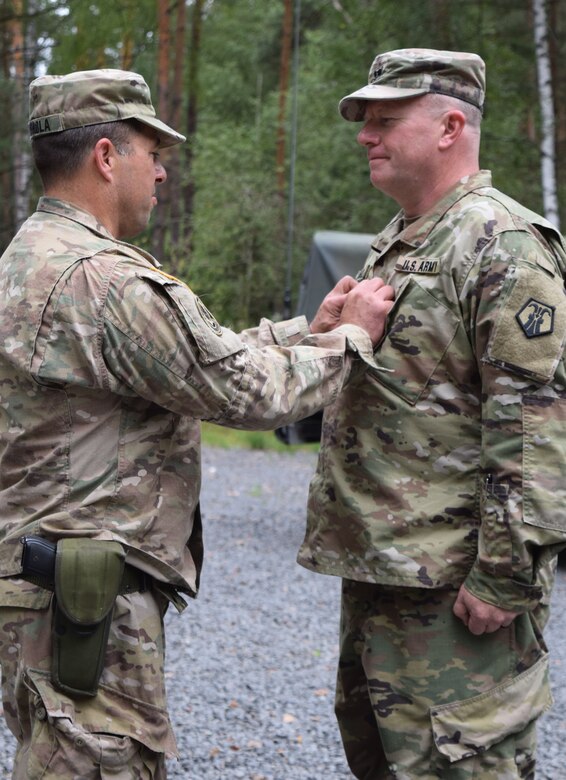 The outgoing commander of the 2500th Digital Liaison Detachment, Col. Christopher Varhola, thanks his Soldiers after receiving a meritorious service medal during a ceremony Aug. 17 at Camp Normandy, Grafenwoehr, Germany. Varhola will retire this November after almost 30 years of service in the U.S. Army.