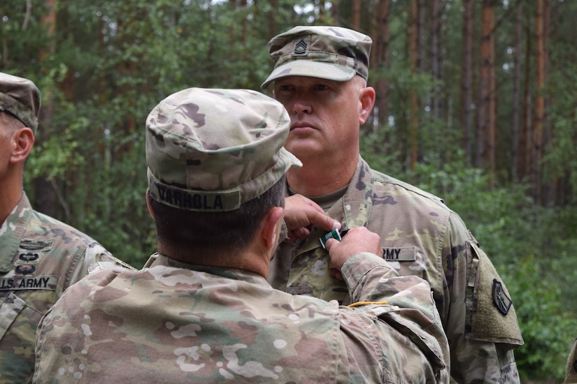 Soldiers with the 2500th Digital Liaison Detachment were recognized for their achievements and service during an awards and promotion ceremony Aug. 17 at Camp Normandy, Grafenwoehr, Germany. The recognition was the final act of outgoing commander Col. Christopher Varhola as he emphasized that his command was only possible because of the individuals who make up the unit.