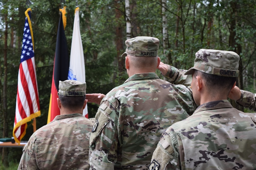 After three years in the position, Col. Christopher Varhola relinquished command of the 2500th Digital Liaison Detachment to Col. Gregory Gimenez during a change of command ceremony Aug. 17 at Camp Normandy, Grafenwoehr, Germany.