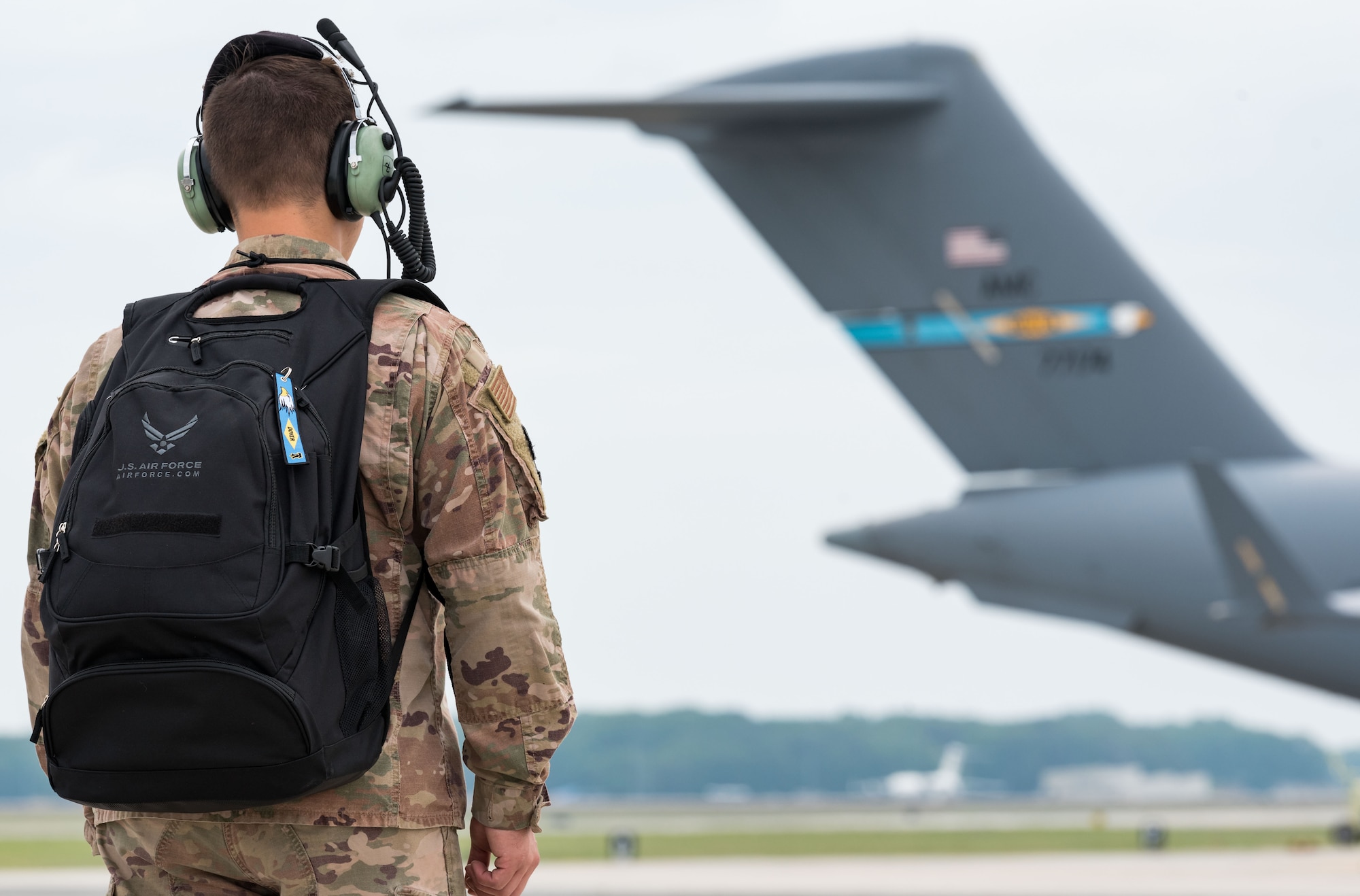 An Airman walks down the flight line carrying his backpack June 18, 2019, on Dover Air Force Base, Del. Metaphorically speaking, each of us may carry our personal backpacks filled with day-to-day struggles of life that are not visible to our Wingmen, family members and others. For Dover Airmen or family members in need of help, visit https://www.dover.af.mil/-We-Care-Guide/. (U.S. Air Force photo by Roland Balik)