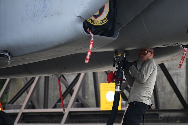 A crew chief assigned to the 748th Aircraft Maintenance Squadron attaches the fuel line to an F-15C Eagle at Roya Air Force Lakenheath, England, Aug. 13, 2019. Crew chiefs work closely with 48th Logistics Readiness Squadron Airmen when fueling aircraft. (U.S. Air Force photo by Airman 1st Class Shanice Williams-Jones)