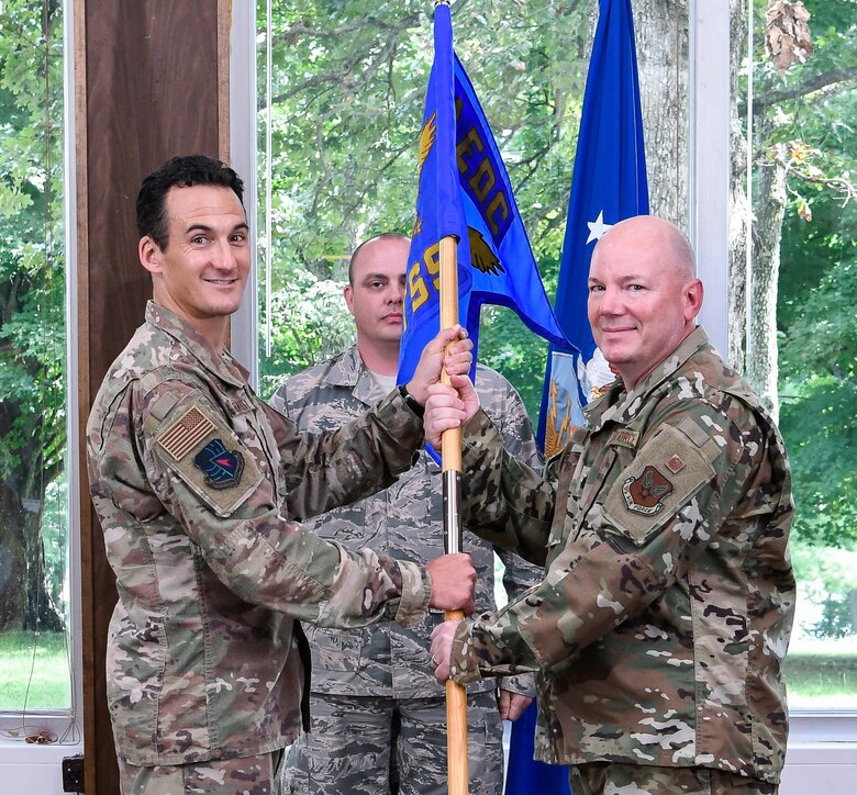 AEDC Commander Col. Jeffrey Geraghty, left, passes the Test System Sustainment Division guidon to incoming division chief Lt. Col. Jeffrey Burdette during an Assumption of Leadership Ceremony Aug. 9 at the Arnold Lakeside Center on Arnold Air Force Base. (U.S. Air Force photo by Jill Pickett)