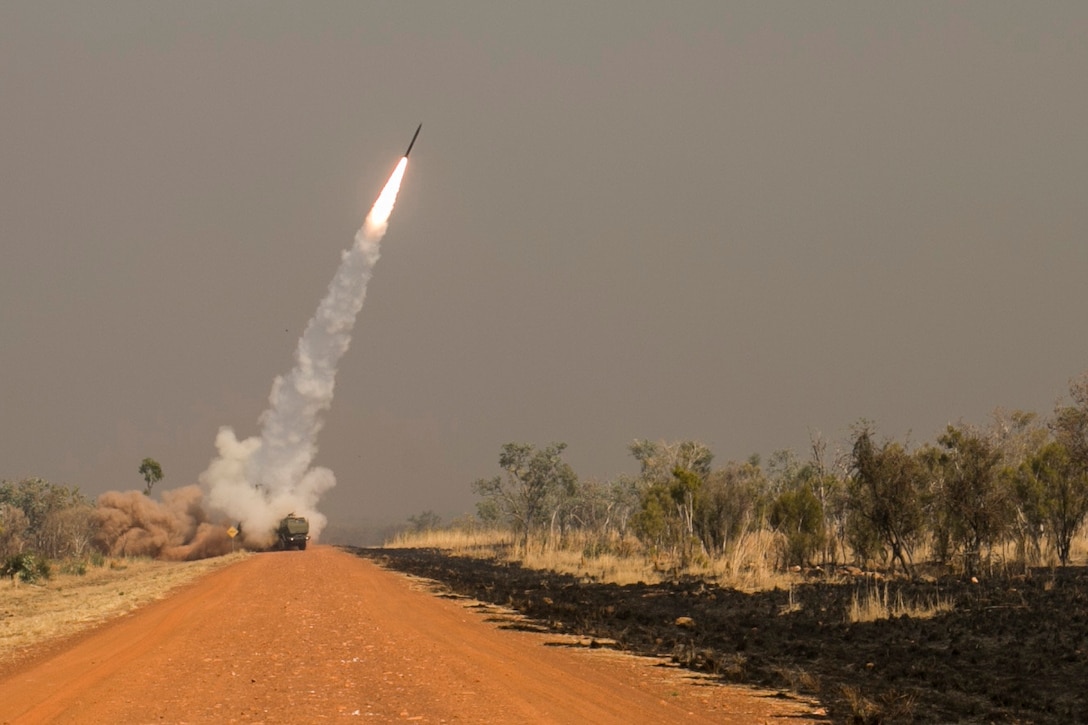 A missile is launched against a grey sky.