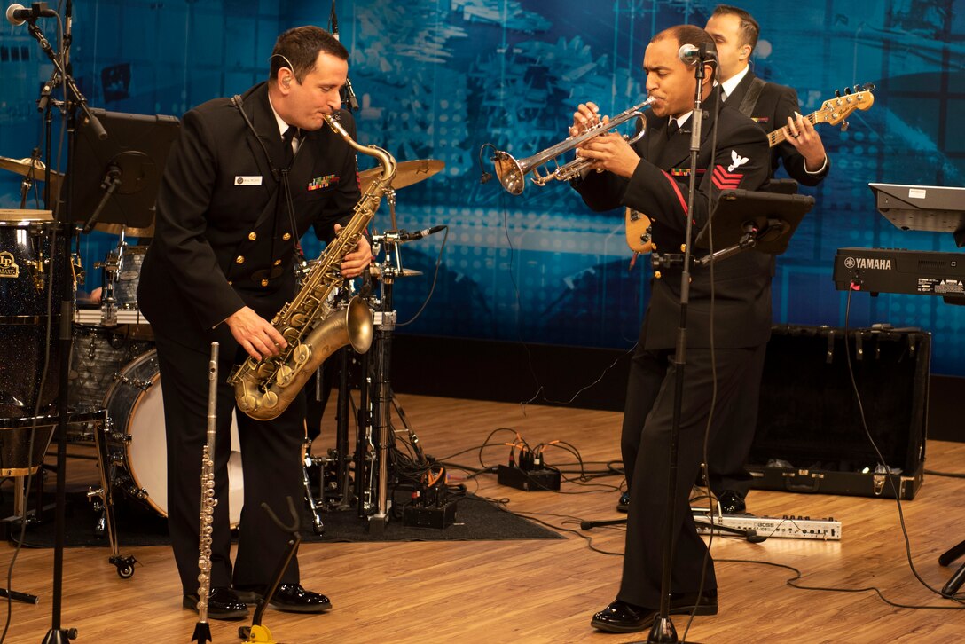 Members of a Navy band play instruments.