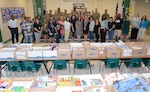 Briscoe Elementary School staff and Soldiers from the 187th Medical Battalion pose in front of more than $10,000 worth of donated school supplies Aug. 8.