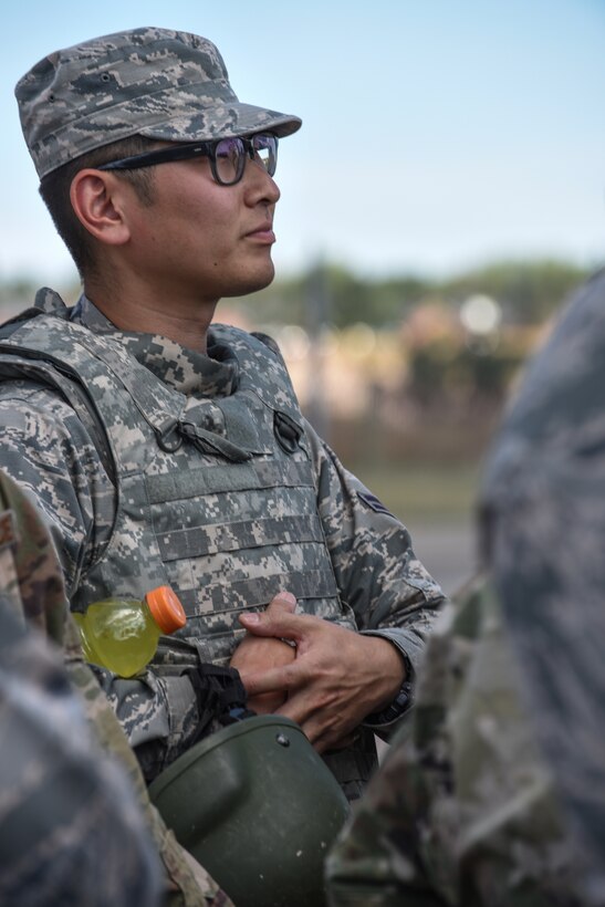 Airman 1st Class Daniel Masahiro Kim, 90th Civil Engineer Squadron power production, listens to a briefing before participating in a tactical convoy exercise during a 90th Mission Support Group Warrior Day Aug. 15, 2019, on F.E. Warren Air Force Base, Wyo. The convoy ran Airmen through a village, allowing them to participate in a simulated rescue and recovery of an injured pilot. (U.S. Air Force photo by Senior Airman Abbigayle Williams)