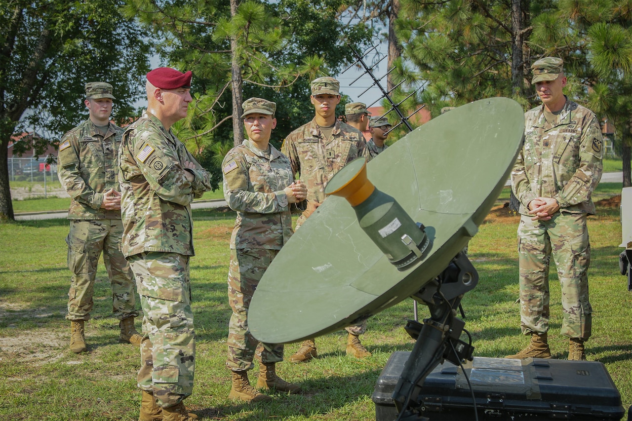 Troops stand around satellite dish