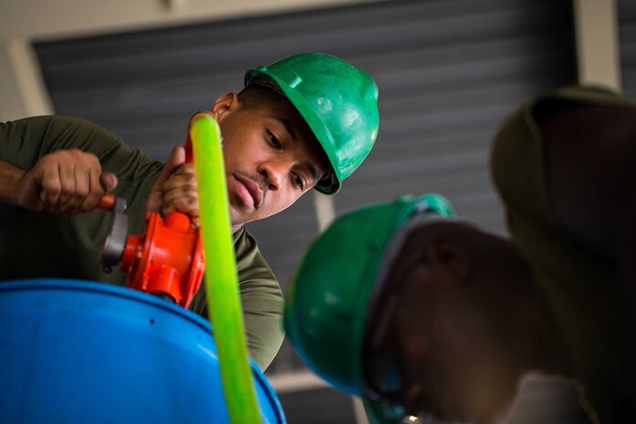 U.S. Marine Corps Cpl. Alexander Roserieerden, left, and Lance Cpl. Marcelius Williams replace radiator fluid of a tactical vehicle as a part of preventative maintenance on Camp Kinser, Okinawa, Japan, August 16, 2019. Preventative maintenance is done regularly to ensure proper vehicle functionality. Roserieerden, a native of the U.S. Virgin Islands, is a motor transportation technician with Motor Transport Maintenance Company, 3rd Maintenance Battalion, 3rd Marine Logistics Group. Williams, a native of Detroit, Michigan, is a motor transportation technician with MTM Co., 3rd Maint. Bn., 3rd MLG.  (U.S. Marine Corps photo by Lance Cpl. Isaiah Campbell)