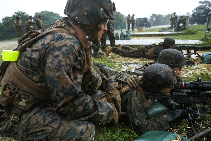 U.S. Marine Corps Cpl. Michael Lien, left, instructs Marines during a machine gun range on Range 7, Camp Hansen, Okinawa, Japan, June 20, 2019. During the range, Marines with Communications Company, Combat Logistics Regiment 37, 3rd Marine Logistics Group, trained to improve field communications skills while employing M249 light machine guns, M240B medium machine guns and .50 caliber machine guns. Lien, a native of Castaic, California, is a weapons instructor with Tactical Readiness and Training Platoon, CLR-37, 3rd MLG. (U.S. Marine Corps photo by Cpl. Joshua Pinkney)